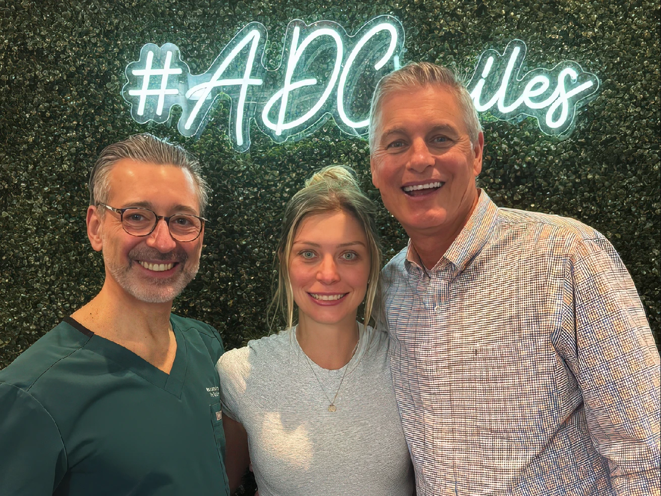 Patient smiling with his daughter and Dr. Meskin after getting porcelain veneers
